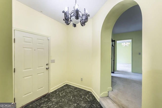6909 Forsyth Rd, Macon, GA 31210 - foyer featuring a chandelier, arched walkways, and carpet