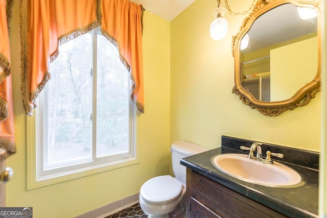 bathroom with tile patterned floors, a shower with door, vanity, and toilet