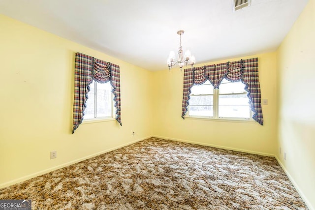 carpeted empty room with plenty of natural light and a chandelier