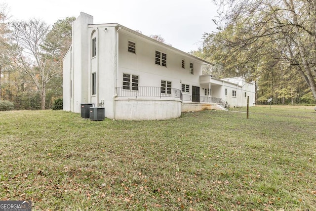 rear view of property with a lawn and central AC unit