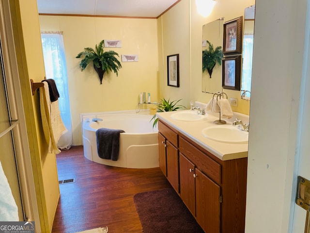 bathroom featuring hardwood / wood-style floors, vanity, and a tub