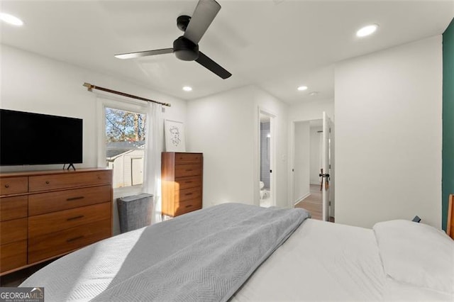 bedroom featuring ceiling fan, wood-type flooring, and ensuite bath