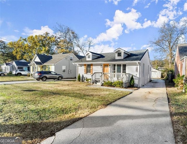 view of front of home featuring covered porch, an outbuilding, a garage, and a front yard