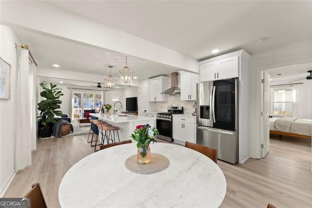 dining room with light hardwood / wood-style floors, sink, and an inviting chandelier