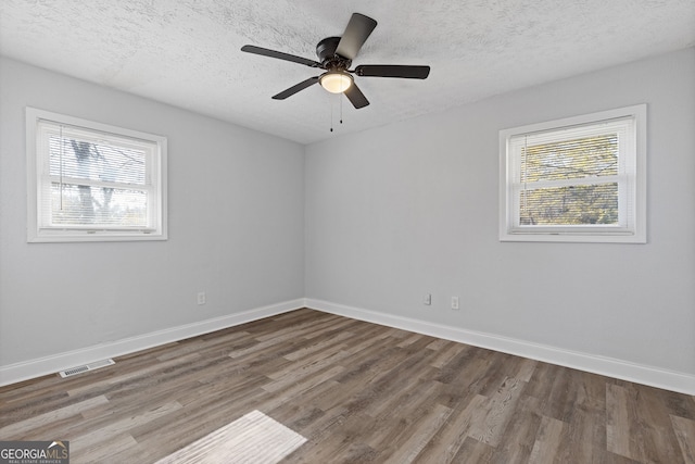 empty room featuring ceiling fan, wood-type flooring, and a textured ceiling