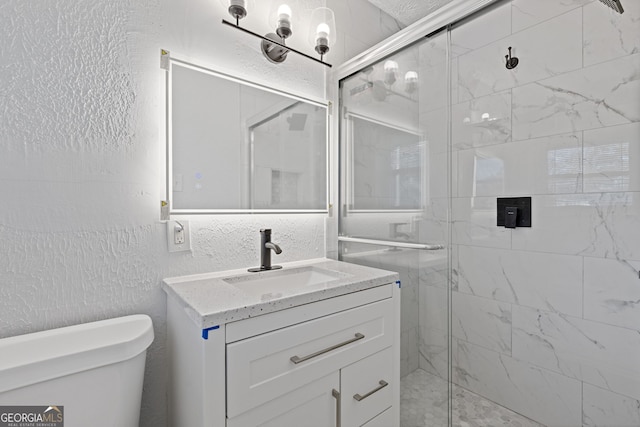 bathroom featuring vanity, toilet, and a shower with door