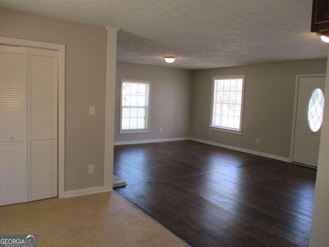 entrance foyer featuring a textured ceiling and dark wood-type flooring