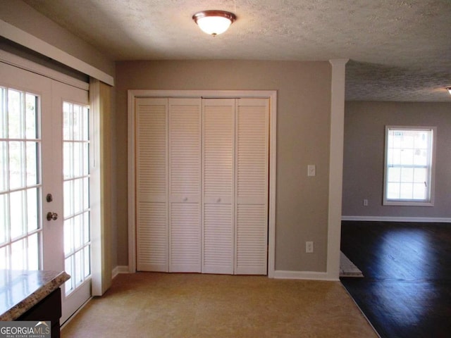 unfurnished bedroom with a closet, multiple windows, and french doors