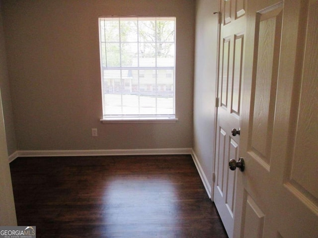 unfurnished room featuring dark wood-type flooring