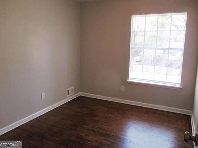 unfurnished room featuring dark wood-type flooring