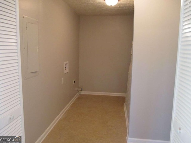 clothes washing area featuring hookup for a washing machine, a textured ceiling, and electric panel