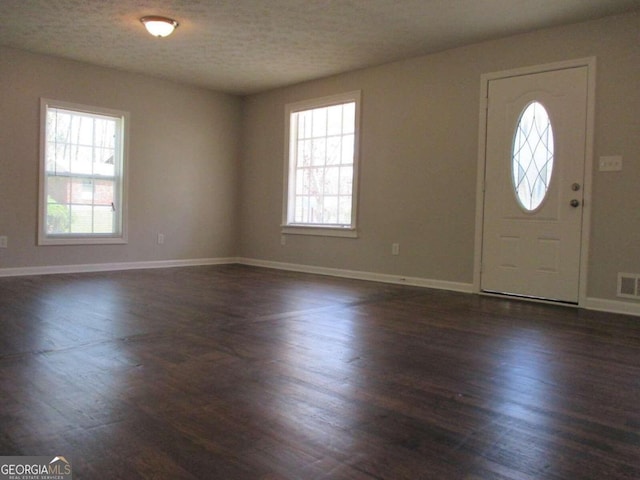 entrance foyer featuring a textured ceiling and dark hardwood / wood-style flooring