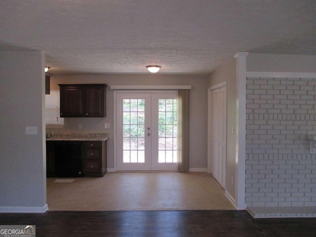 doorway with french doors, dark wood-type flooring, a textured ceiling, and sink