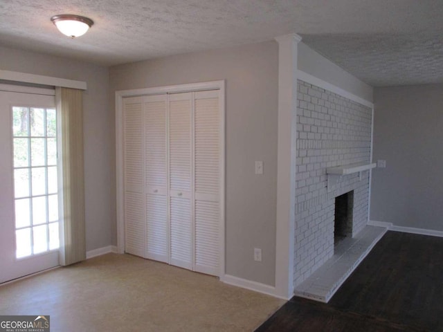 unfurnished living room featuring a fireplace, a textured ceiling, and hardwood / wood-style flooring