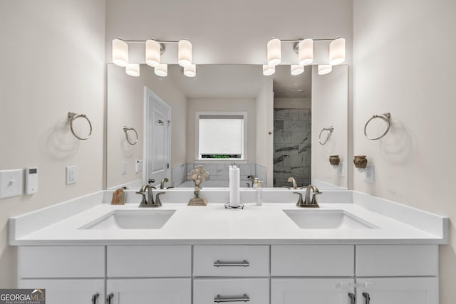 bathroom featuring tiled shower and vanity