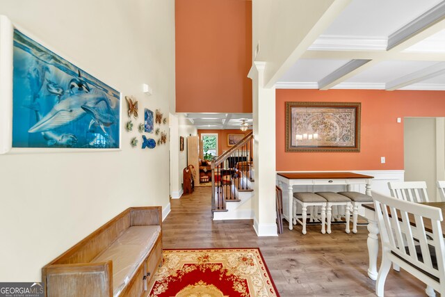 living room with beam ceiling, light wood-type flooring, and coffered ceiling