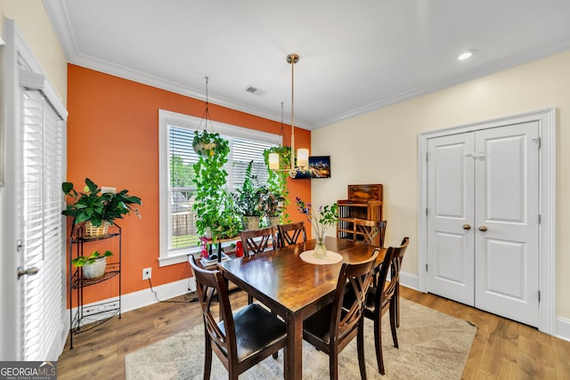 dining area with hardwood / wood-style floors and ornamental molding