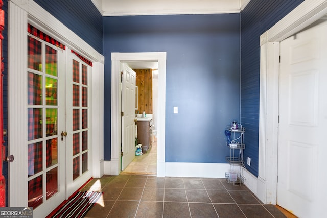 interior space featuring french doors, dark tile patterned floors, and ornamental molding