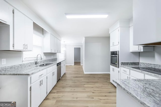 kitchen with light wood-type flooring, white cabinetry, sink, and appliances with stainless steel finishes