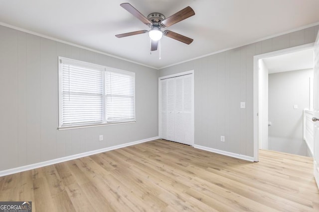 unfurnished bedroom with light wood-type flooring, a closet, ceiling fan, and crown molding