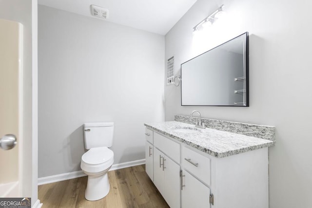 bathroom with vanity, toilet, and wood-type flooring