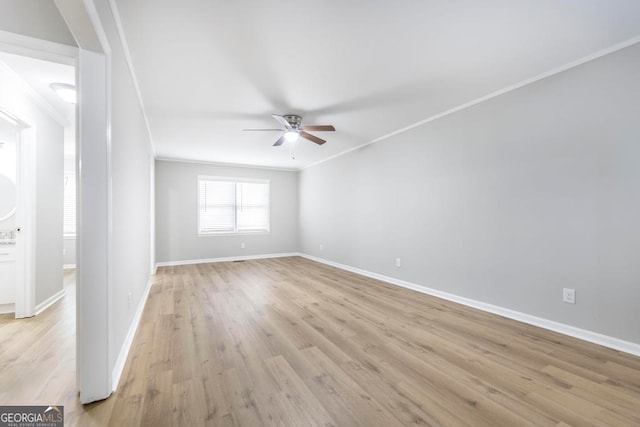 empty room featuring ceiling fan, light wood-type flooring, and ornamental molding