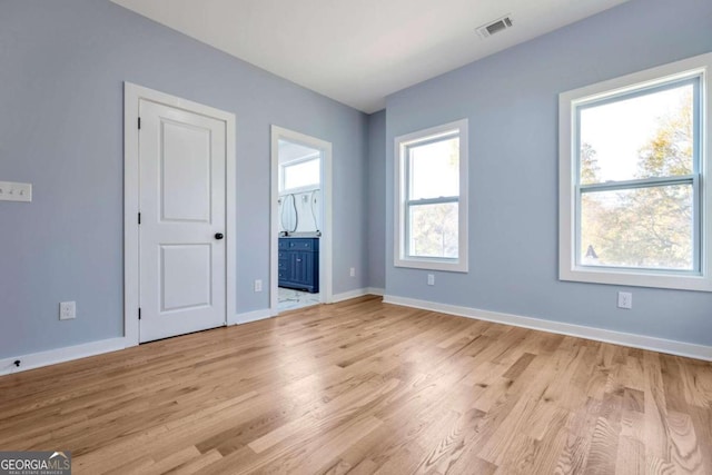 unfurnished bedroom with connected bathroom and light hardwood / wood-style flooring