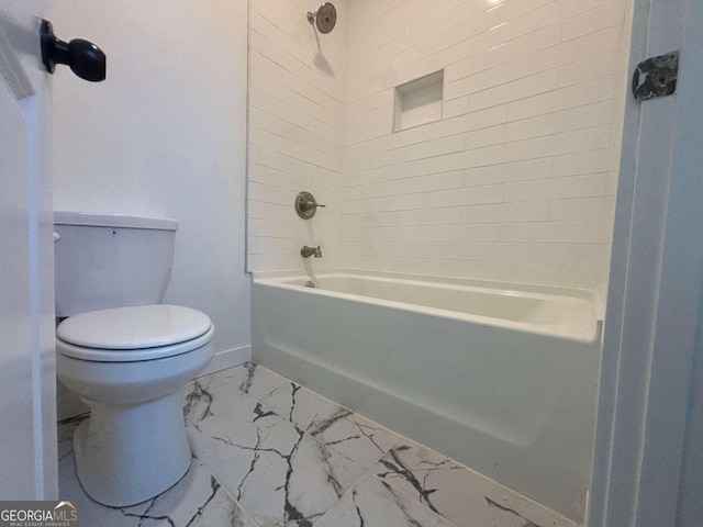 bathroom with tiled shower / bath combo and toilet