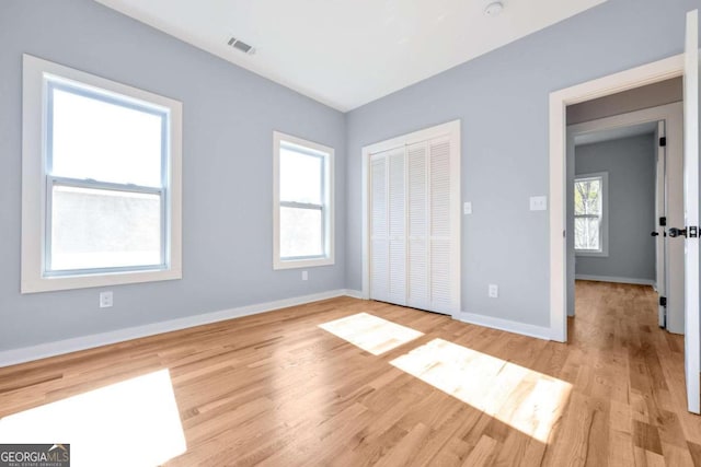 unfurnished bedroom with a closet and light hardwood / wood-style flooring