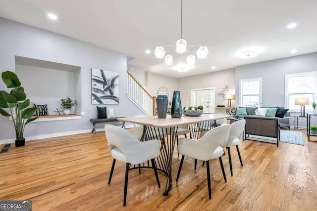 dining space featuring light hardwood / wood-style flooring and a chandelier