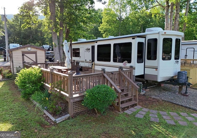 back of property with a storage unit and a deck