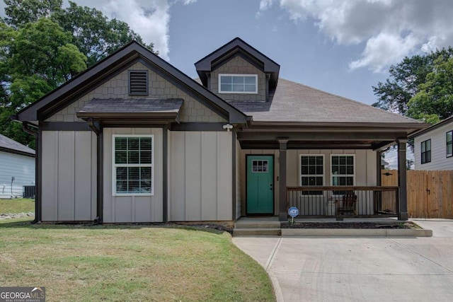 view of front facade with central air condition unit, a porch, and a front yard