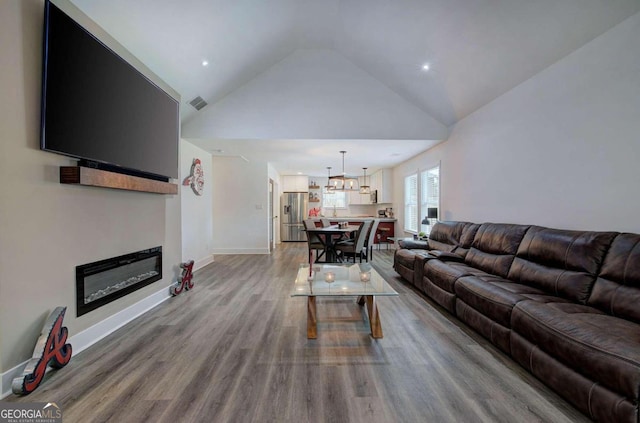 living room with hardwood / wood-style floors and vaulted ceiling