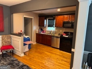 kitchen with light hardwood / wood-style flooring and black appliances