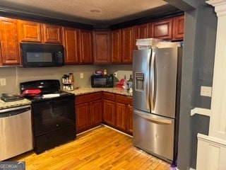 kitchen featuring black appliances and light hardwood / wood-style flooring