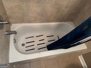 bathroom featuring tile patterned floors and tiled tub