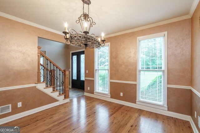 2505 Westchester Way, Conyers, GA 30013 - unfurnished dining area featuring wood finished floors, a chandelier, stairs, and crown molding