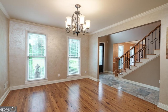 unfurnished dining area featuring hardwood / wood-style floors, crown molding, and a notable chandelier