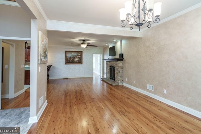 2505 Westchester Way, Conyers, GA 30013 - unfurnished living room with light wood-style floors, crown molding, a stone fireplace, ceiling fan, and a chandelier