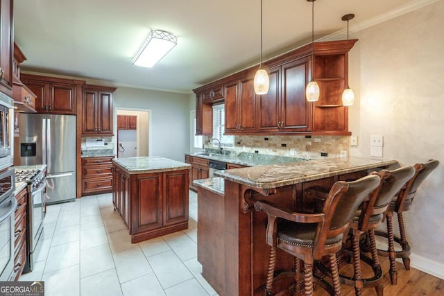 kitchen with kitchen peninsula, dark stone counters, decorative backsplash, a kitchen island, and appliances with stainless steel finishes