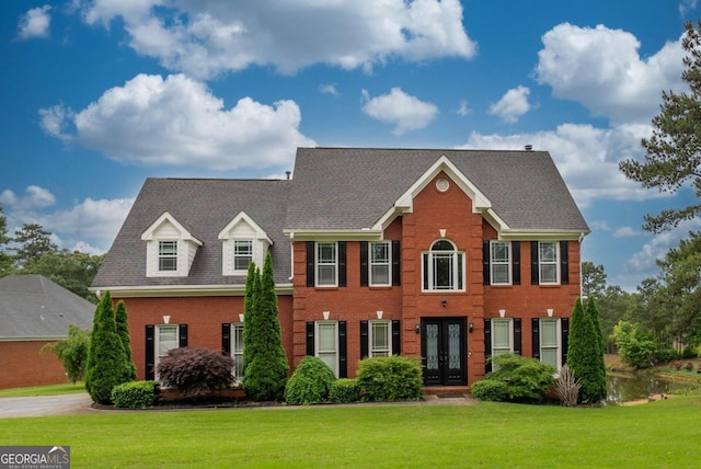 2505 Westchester Way, Conyers, GA 30013 - colonial-style house featuring french doors, a front yard, and brick siding