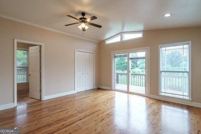 unfurnished bedroom featuring access to outside, ceiling fan, light hardwood / wood-style flooring, a closet, and lofted ceiling