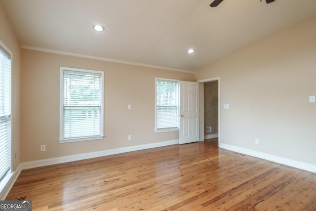 spare room with ceiling fan, light hardwood / wood-style floors, ornamental molding, and vaulted ceiling