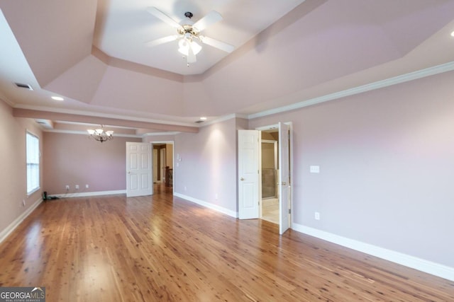 unfurnished room featuring a raised ceiling, crown molding, and light hardwood / wood-style flooring