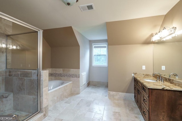 bathroom with vanity and tiled tub