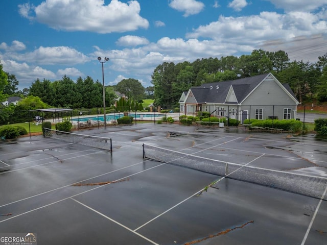 view of sport court with a community pool