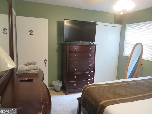 bedroom featuring ceiling fan, a closet, and light colored carpet