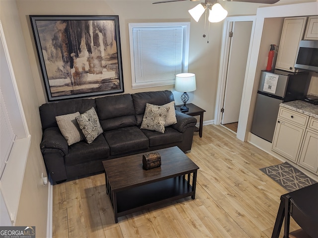 living room with light wood-type flooring and ceiling fan