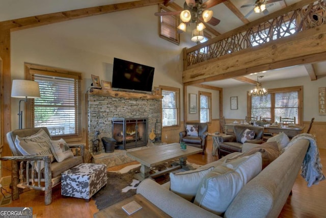 living room featuring hardwood / wood-style flooring, a healthy amount of sunlight, a fireplace, and high vaulted ceiling