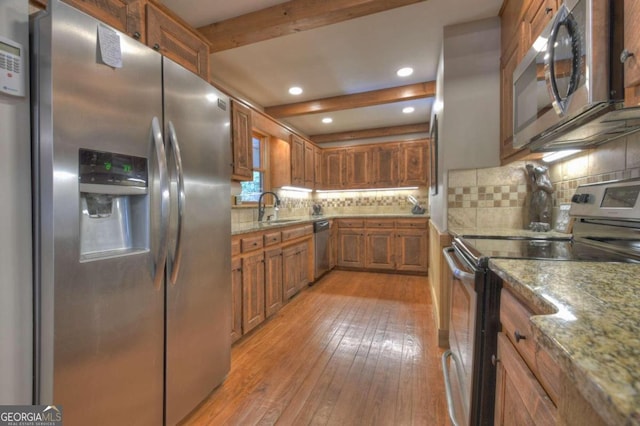 kitchen featuring light stone counters, light hardwood / wood-style flooring, stainless steel appliances, and sink